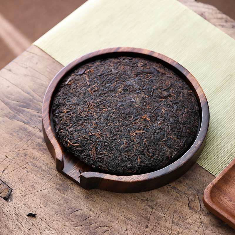 Plateau-boîte en bois présentant une galette de pu-erh