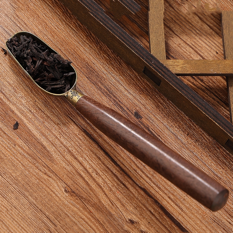 Cuillère à thé sombre sculptée sur une table en bois