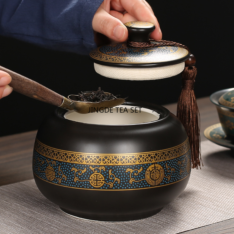 Pot à thé noir décoré ouvert par une main